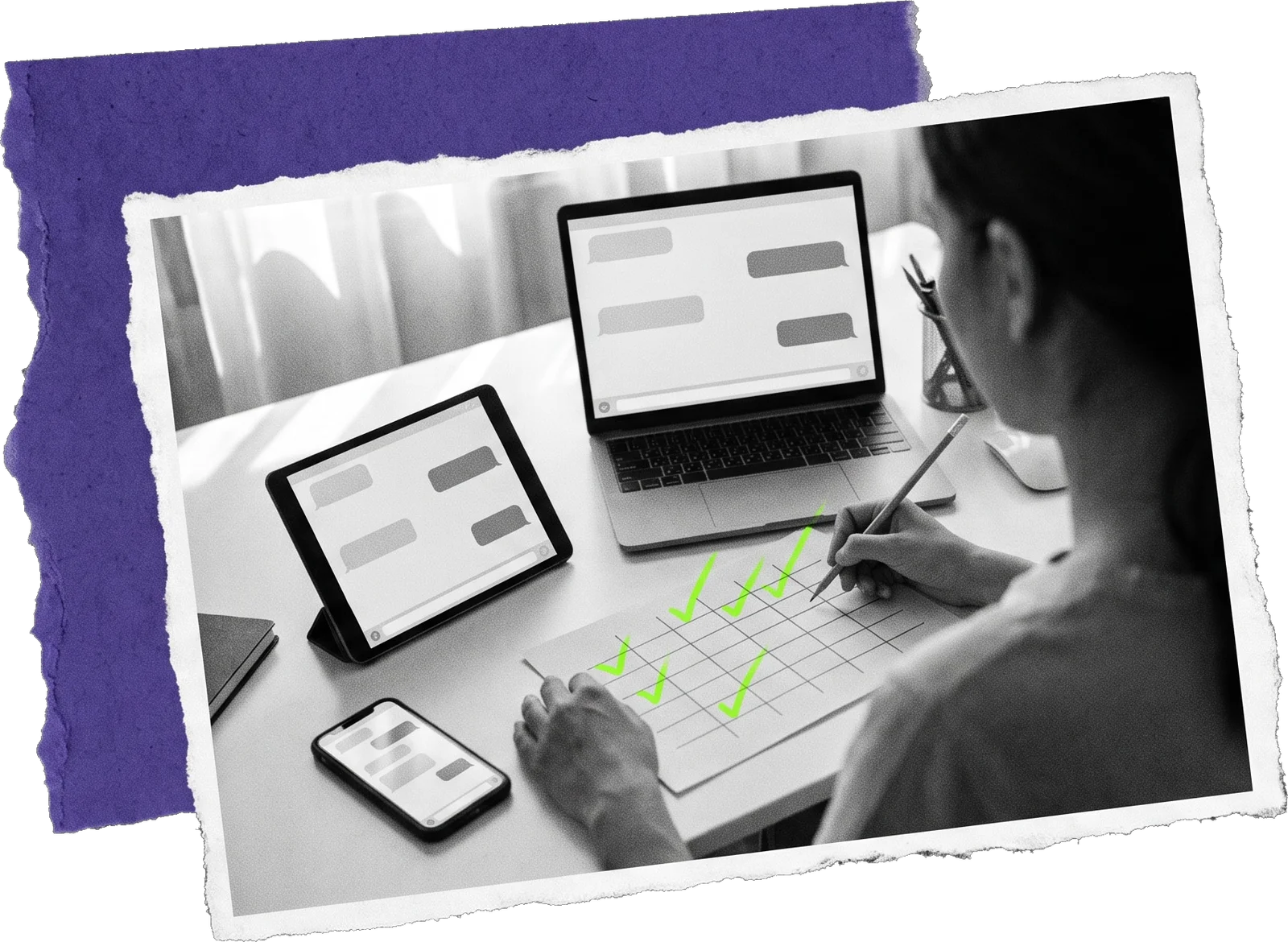 Black-and-white photo of a woman filling in a paper grid with a pen, with a laptop, a tablet and a phone beside her; green ticks mark the grid.