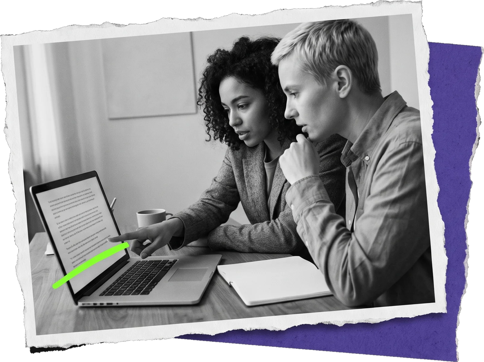 Black-and-white photo of two colleagues reading a page on a laptop; one points at the screen and a green highlight runs under the text.