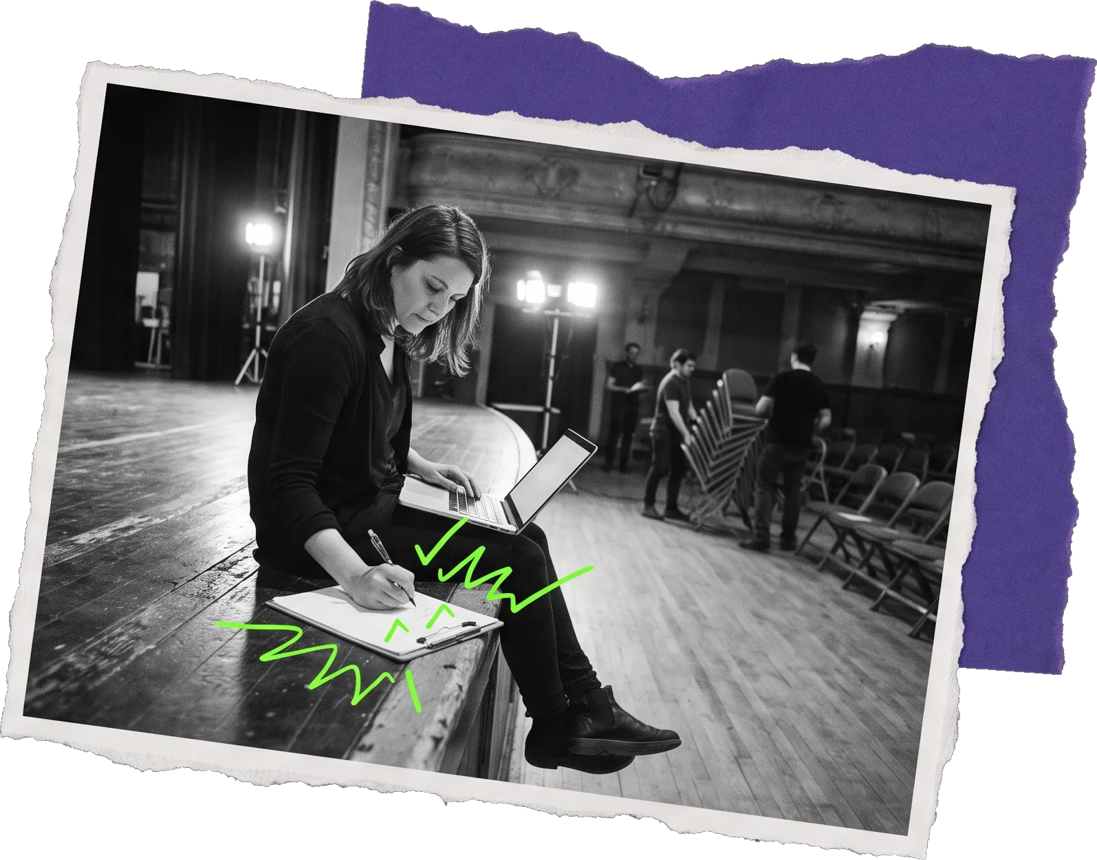 Black-and-white photo of a woman sitting on a stage edge writing on paper with a tablet beside her, green notes scribbled in front of her, with crew and chairs in the background.