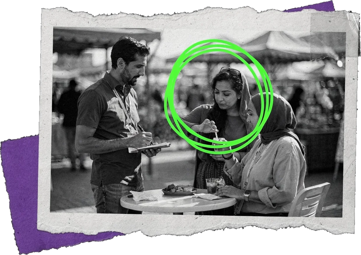 Black-and-white photo of three people at a market table, one holding a notepad while a woman tastes a product; the tasting is circled in green.